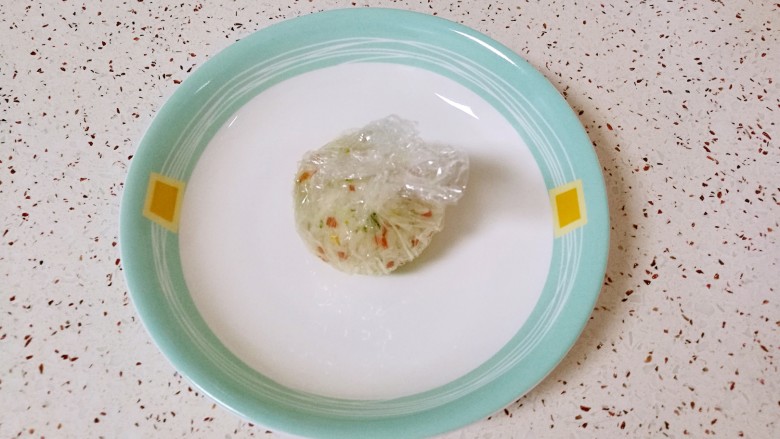 彩蔬饭团,提起保鲜膜的四个角，用手捏紧米饭，做好饭团。