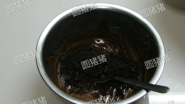 双色冰淇淋蛋糕,奥利奥饼干去糖芯,用搅拌机搅成粉状。加入溶化黑巧克力及溶化黄油拌均匀。