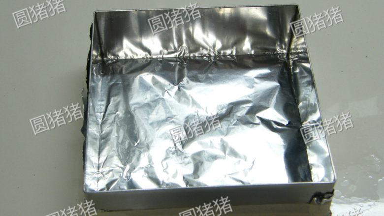 双色冰淇淋蛋糕,用锡纸把幕斯框底部包紧,并用纸胶带粘紧。将(过程2)倒入框内压平整制成饼干底。取两片硬质幕斯片将方框中间间隔开。