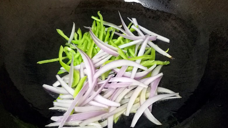 酱油炒面,炒锅内倒适量的食用油烧热,下入青椒和洋葱丝翻炒。