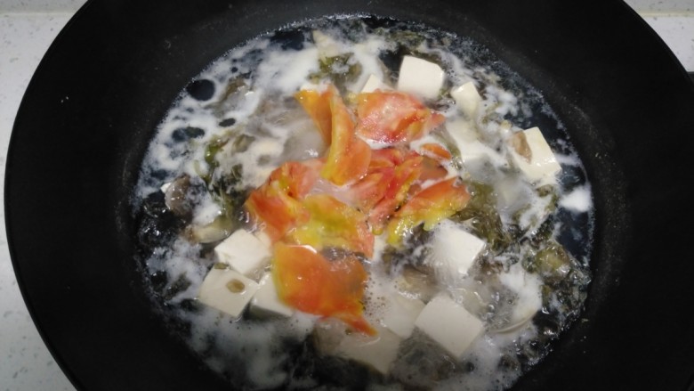 花蛤豆腐苦瓜汤,中火煮5分钟，倒入西红柿。