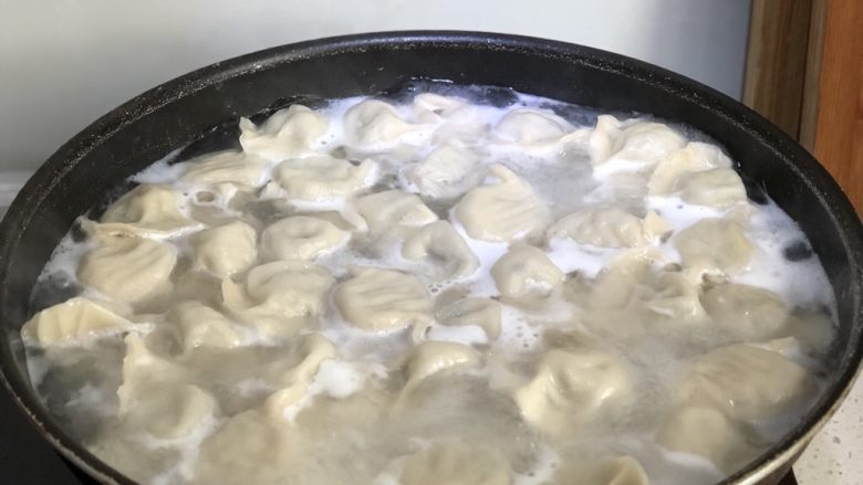 猪油韭菜苔木耳馅饺子,锅里加水烧开之后放入饺子,勺子反面拿进去轻轻的顶一下防止粘锅上,然后就等饺子开锅不要再搅了。