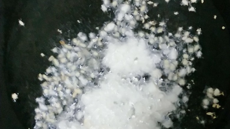 西红柿火腿炒螺丝型意大利面,锅里放适量的油，放入姜蒜爆香。