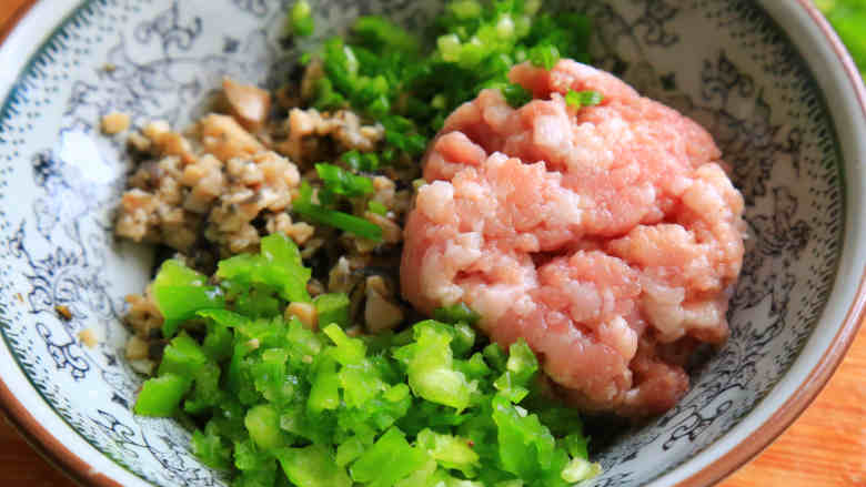 田螺开肉,将田螺肉.青椒分别剁碎,和夹心肉.葱末末放在一起。