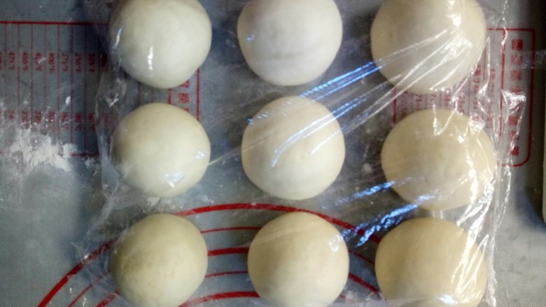 寿桃豆沙包,剩下的白色面团揉成条状,然后切割为9个大小相同的小面团,连绿色面团一起用保鲜膜覆盖,防止表皮吹干。