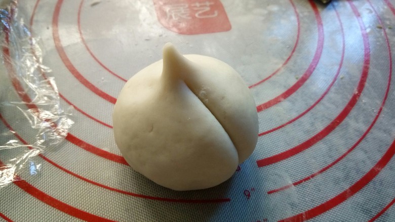 寿桃豆沙包,用手掌在顶端捏出小尖,拿刀背压出痕迹,稍微压深点,因为还要进行二次发酵。依次做好……