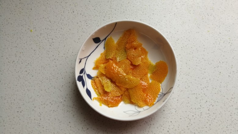 香橙海绵纸杯蛋糕,然后用刮刀刮下橙皮,注意只刮表面不要刮到白色部分。