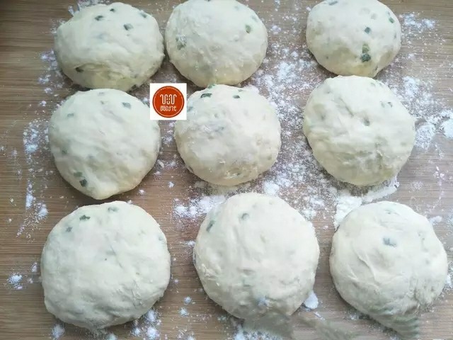 葱花饼,案板上撒入一些面粉,把发好的面倒出来,揉一揉排排气,接着分成大小差不多的团,再饧10分钟左右。