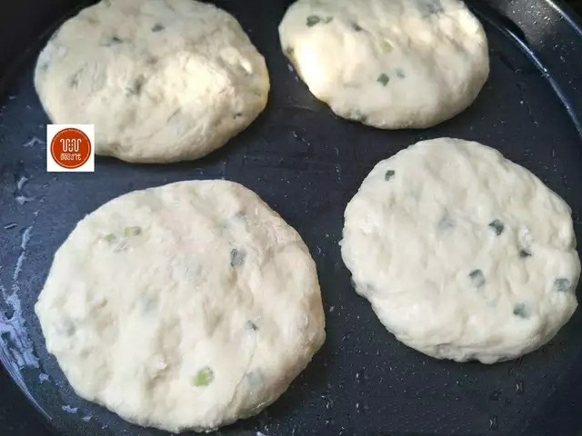 葱花饼,电饼档刷上适量油,接着放入饼坯用手轻轻压一下,压扁。