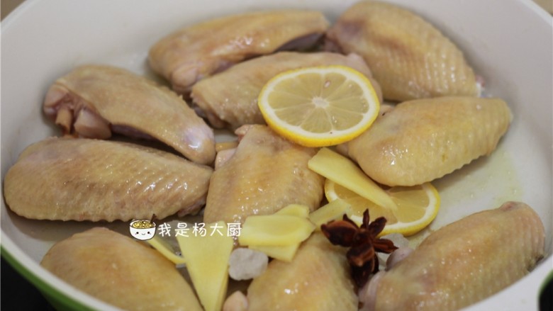 可乐鸡翅,待正面煎至微微黄,上色以后,翻过来再煎反面。两面煎好后放入姜片,八角,冰糖,腌过鸡翅的柠檬片