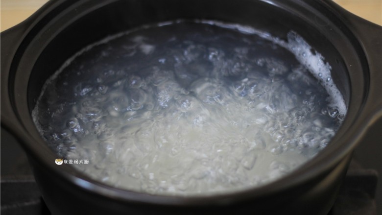 菠菜火腿粥,砂锅中放入适量清水,水开后下米,大火煮开,转小火继续熬煮