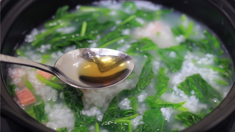 菠菜火腿粥,关火,在锅内加入少许食盐,鸡粉,几滴香油,搅拌均匀
