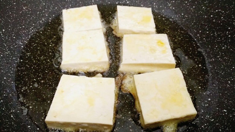 米饭杀手的家常菜~锅塌豆腐,锅内倒入适量油,放入豆腐块,小火慢煎。