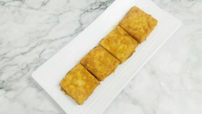 米饭杀手的家常菜~锅塌豆腐,待豆腐一面煎黄后再翻面,煎至两面金黄,出锅装盘待用。