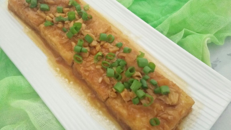 米饭杀手的家常菜~锅塌豆腐,炖至汤汁减少时即可起锅,锅中的汤汁可用粘豆腐时剩下的淀粉勾一下芡,把汤汁淋在豆腐上,最后装盘撒上葱花即可。