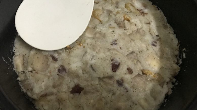 快手早餐腊肠虾米芋头糕,把炒粘的芋头糕倒入抹油的蒸盘里,用饭勺压紧实。