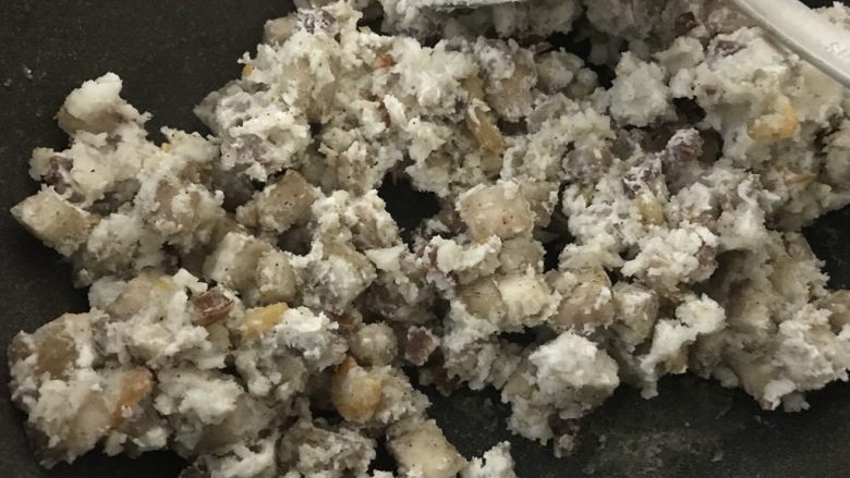 快手早餐腊肠虾米芋头糕,中小火,把粘米粉水用勺子混合均匀后倒入与芋头炒粘合。