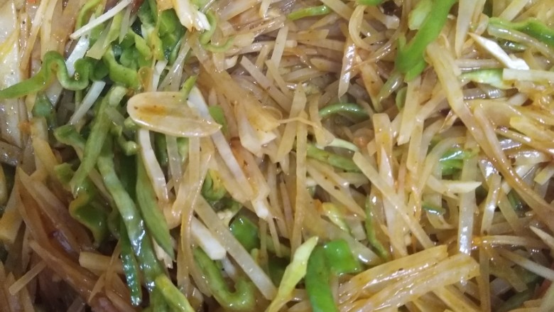 家常酸辣土豆丝,放入青椒翻炒1分钟,放一勺鸡精翻炒