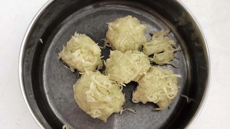 白萝卜韭菜虾仁馅饼,用手挤出萝卜丝里多余的水份,把萝卜丝放入盆中