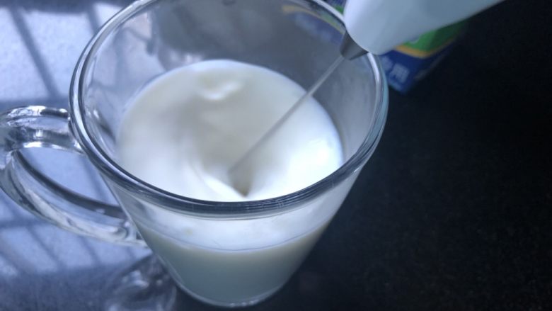 蜜桃乌龙奶茶,取出,耐心的用打奶泡器打出泡,奶泡器不要露出液面。尽量把牛奶打绵密。
