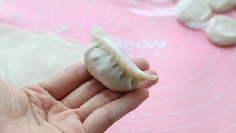 青椒猪肉馅水饺,然后分别从两边捏出褶状,一定要捏住收口,不然煮的时候就容易破掉了