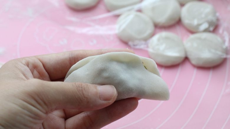 青椒猪肉馅水饺,.对折后先将中间部位捏严,当然每个人包饺子的手法都不一样,按自己平时的习惯来就可以