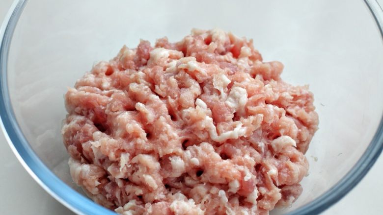 青椒猪肉馅水饺,猪肉剁成肉馅放入容器中,猪肉选择三肥七瘦的,这拌样好的饺子馅口感嫩滑不发柴