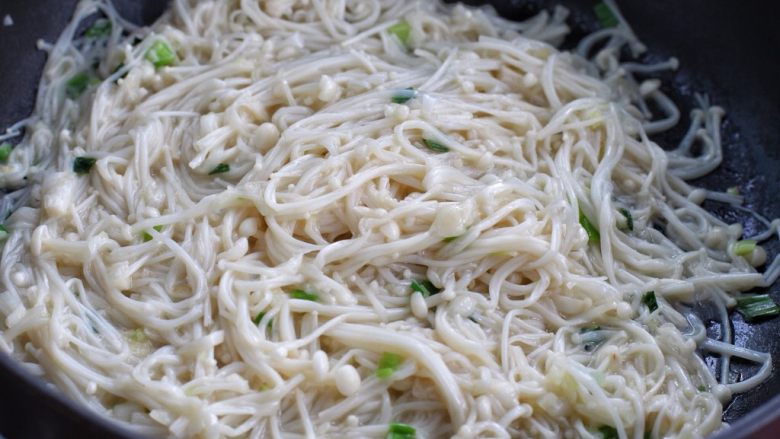 金针菇日本豆腐,接着放入金针菇翻炒变软,可以用筷子来回翻拨