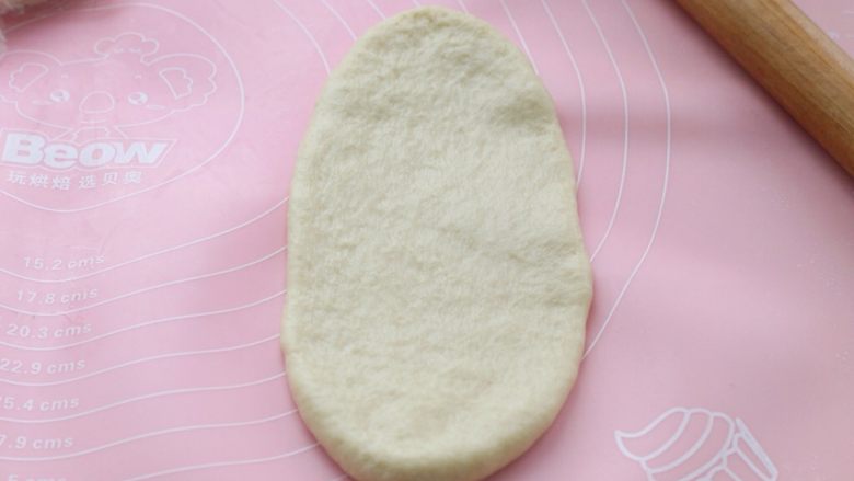 淡奶油老式面包,取一个松弛好的面团,用擀面杖擀成椭圆形