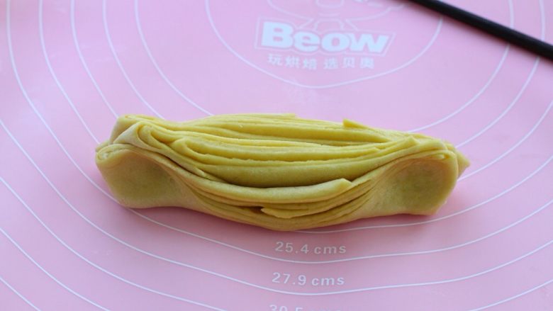 南瓜泥花卷,然后将面剂子就着筷子压下去的痕迹对折,两只手分别捏住两边轻轻抻一下