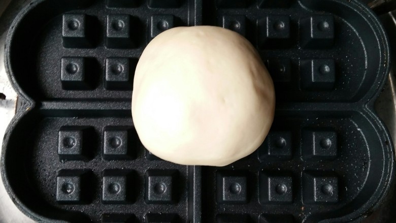 红豆沙椰蓉华夫格格(发面版),华夫饼锅预热后放入包好馅的面团,扣上盖,多次翻转至两面均匀受热。