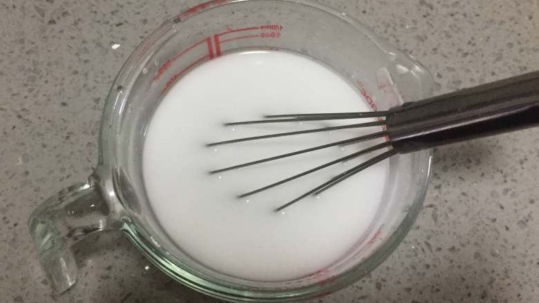 酸辣凉粉,首先我们把125克的豌豆淀粉和200毫升的清水混合,用蛋抽搅拌均匀至完全溶解。