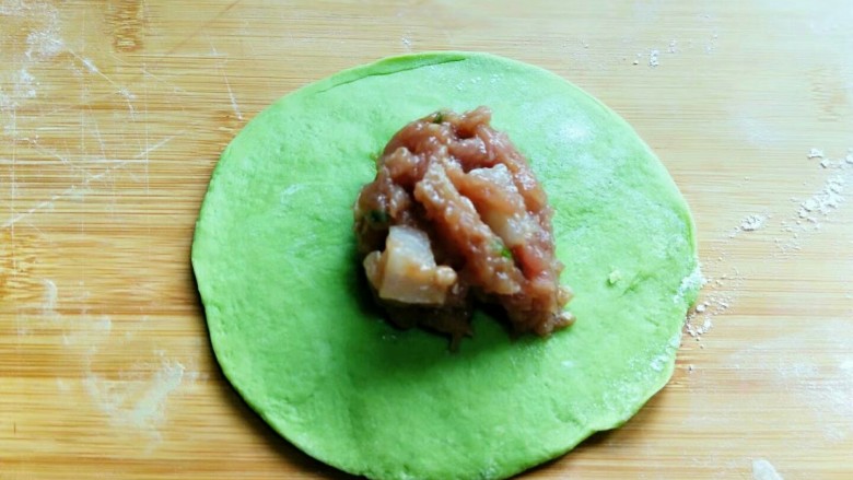 小清新&翡翠肉包,取一块面团,用擀面杖擀圆,加入肉馅。
