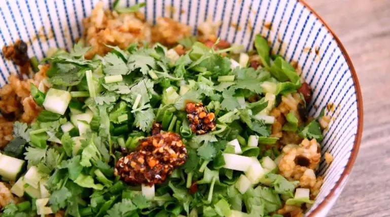 东北经典传统小吃:东北饭包,再加入生菜、黄瓜、小葱、香菜碎,一勺辣油,拌匀
