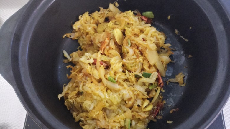 酸菜粉丝羊肉砂锅,翻炒均匀,把炒好的酸菜倒入砂锅。