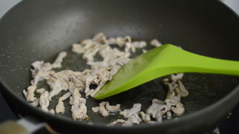 彩椒炒肉丝,炒至肉丝变色后放入姜蒜沫,炒均匀