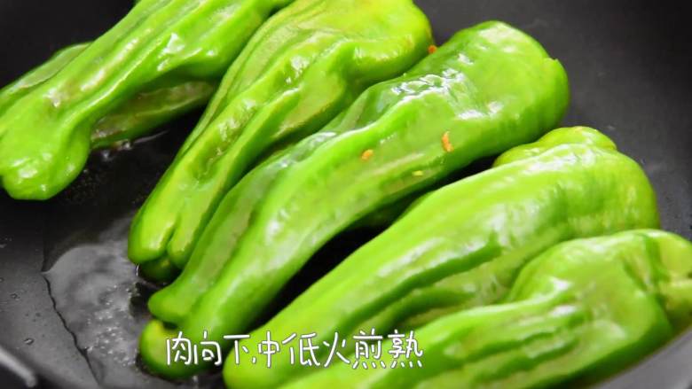 煎酿辣椒—客家名菜煎酿三宝之一,风靡粤港澳,热锅冷油,放入辣椒,肉向下,中低火煎熟。