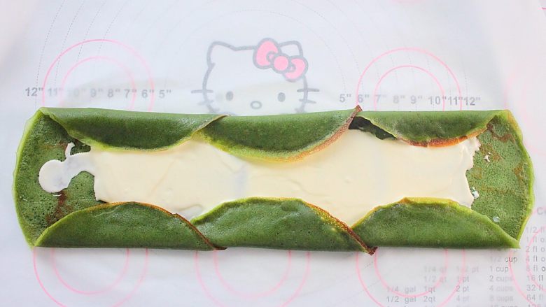 那一抹毛巾卷的绿,将饼边依次向内折叠,这样可以避免奶油漏出