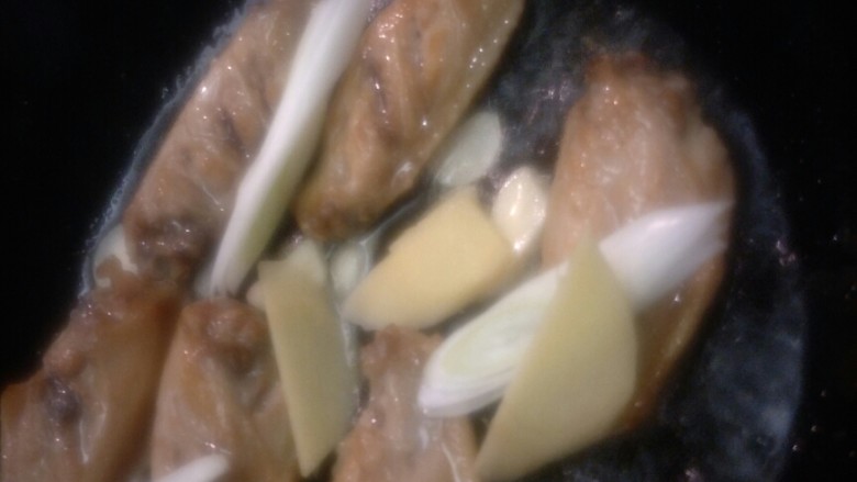 家常可乐鸡翅,把葱姜蒜放入,煸出香味
