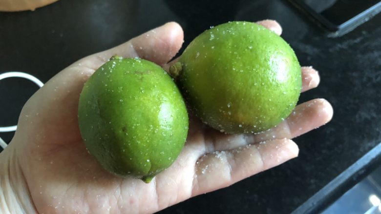 快手小食 仿茶餐厅冰爽咸柠七,用一茶匙盐将青柠表皮细细搓一下,清水冲干净,用厨房用纸擦干。