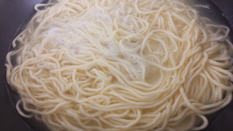 红烧牛肉面,锅里烧开水,把面条放进去煮。