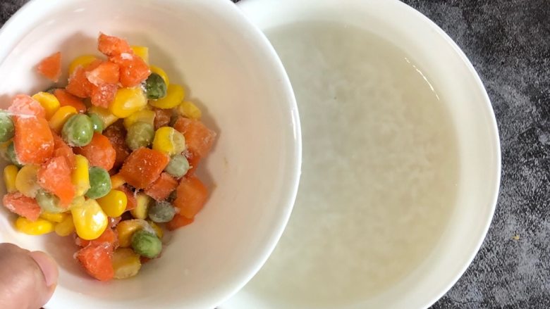 宝宝最爱的蔬菜粥,锅中大米倒入几滴核桃油,把地胡萝卜、玉米、青豆倒入进煮开的大米中里,