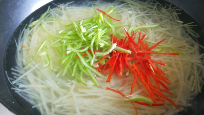 快手正餐 凉拌土豆丝,锅中放入半锅水烧开,倒入土豆丝,在倒入尖椒,小米辣丝,煮1分钟捞出来。
