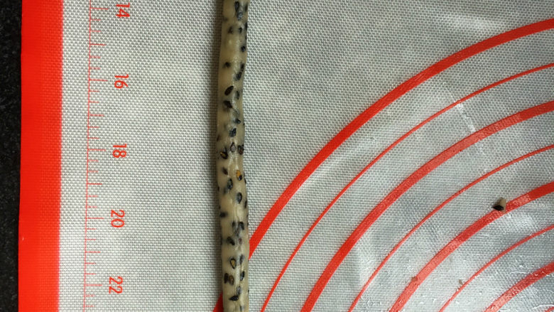 黑芝麻咸味普雷结,用手把切好的细条捏一下,搓成圆的细条