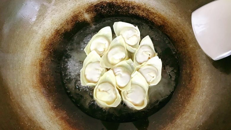 生煎饺子,盖上盖子煎煮。