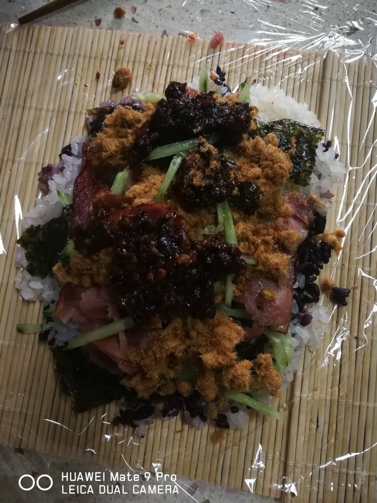 二色糯米饭团,来吧,蒸好的糯米,放在保鲜膜上,上面可以放上自己喜欢的蔬菜,再放上酱汁,我这个酱是自己秘制的肉酱再卷上