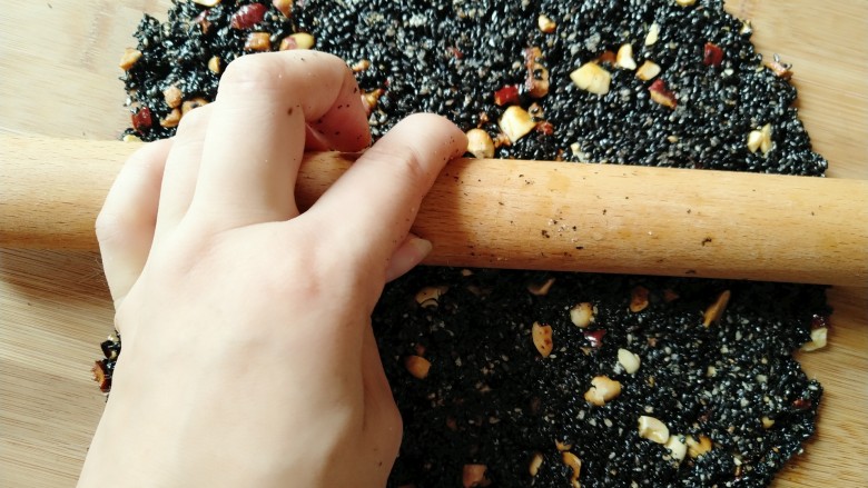 黑芝麻糖,把芝麻倒在菜板上 快速擀平,动作一定要快。