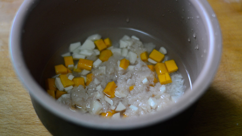南瓜山药焖饭(辅食),将浸泡大米的水倒掉,重新注入清水(要比平时煮饭的水量多一点)再将山药、南瓜和鸡肉均匀的铺在大米上面