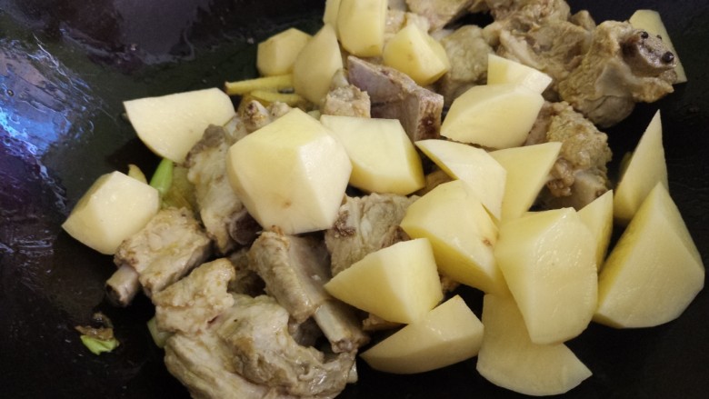 土豆炖排骨,把排骨炒匀,然后加入土豆块。