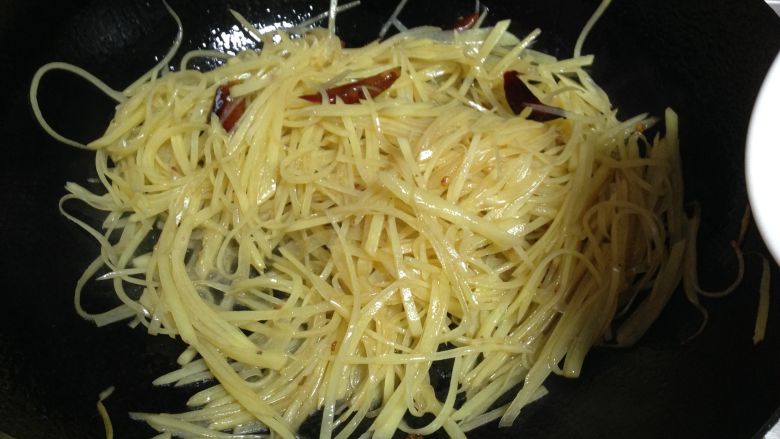 酸辣土豆丝,
倒入土豆丝转大火快速煸炒,同时加入1/2小勺米醋迅速炒匀